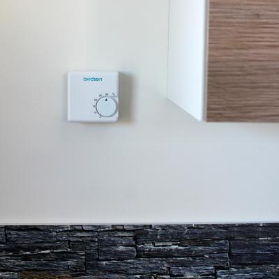 thermostat mécanique filaire avidsen posé sur un mur