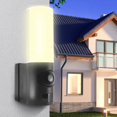 Lampe extérieure allumée sur le mure d'une maison avec une caméra de surveillance