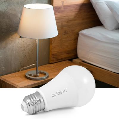 Ampoule connectée Avidsen Home à côté d'une lampe de chevet